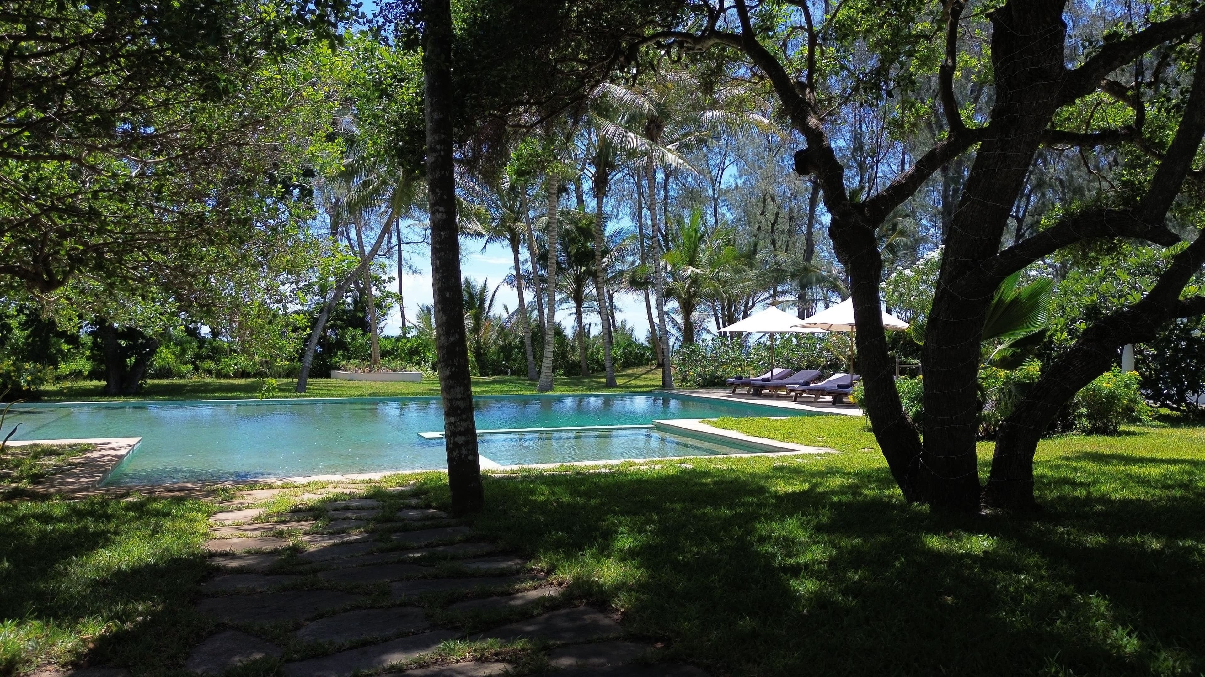 Emerald swimming pool surrounded by tropical gardens at Zuri Boutique Hotel, Watamu